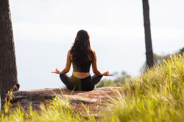 back view asian woman doing yoga poses at outdoors