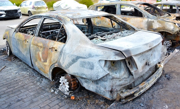 Photo a back view of a blown up down car a charred burned down vehicle in the city center in residential