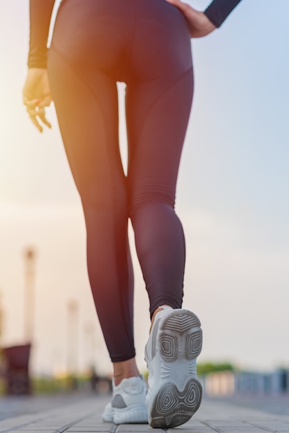 Back view of body sexy young woman in sport sneakers outside