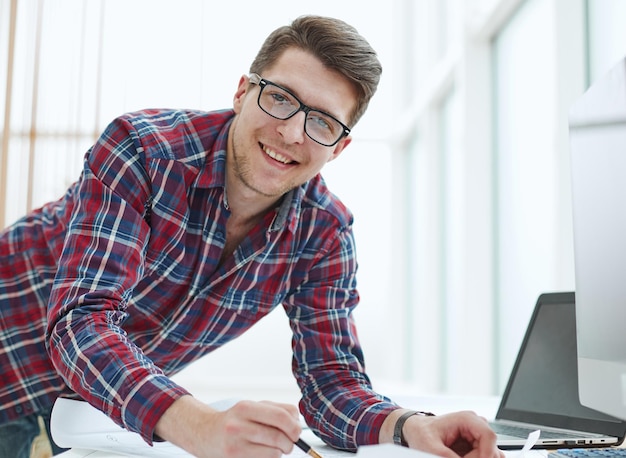 Back view of businessman sitting in front of laptop screen Man typing on a modern laptop in an office Young student typing on computer sitting at wooden table