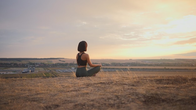 Back view of the caucasian women sitting at the hill and relaxing during the holiday