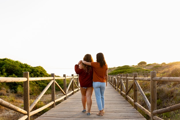 Back view of embraced female friends outdoors