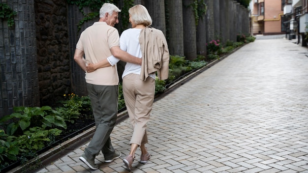 Back view of embraced senior couple taking a walk outdoors