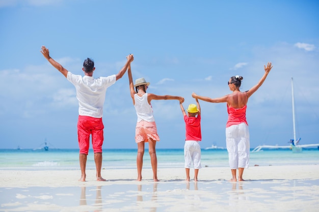 Back view of Happy family having fun on tropical beach