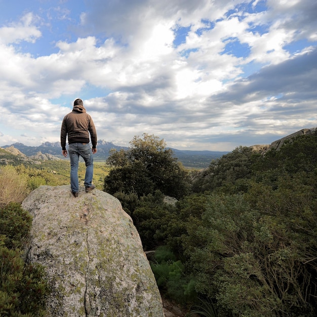 Back view of a male hiker looking at the view from a peak