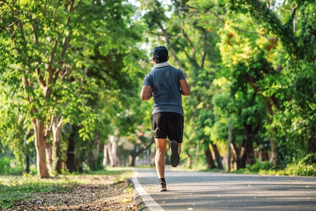 Back view of man jogging or running exercising outdoors in park, Concept of healthy lifestyle.