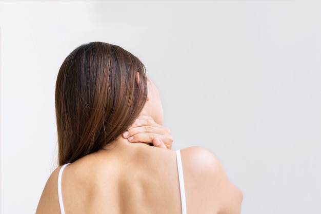 Back view of oung Asian woman suffering from neck pain isolated on white background studio shot Copy space close up