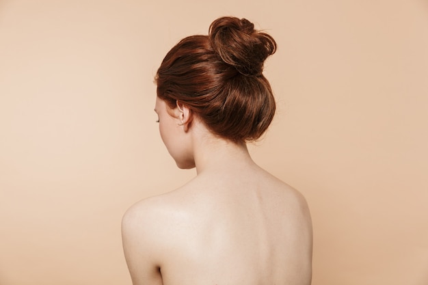 Back view photo of a young redhead woman posing isolated.