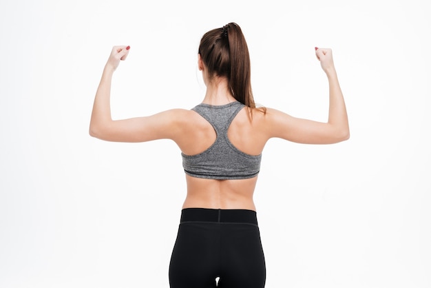 Photo back view portrait of a fitness woman showing her biceps isolated 