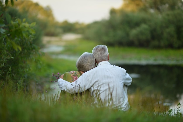 Back view of senior couple sitting on grass