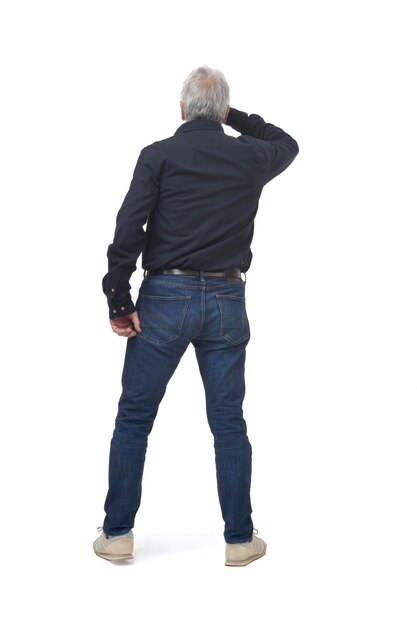 Back view of standing man looking away with hand on forehead on white background