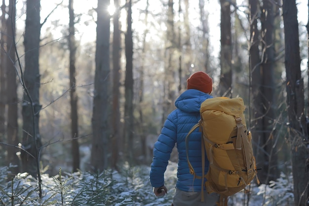 back view of  tourist with  backpack hiking in winter in Norway / one man carrying  backpack in a Norwegian winter landscape.