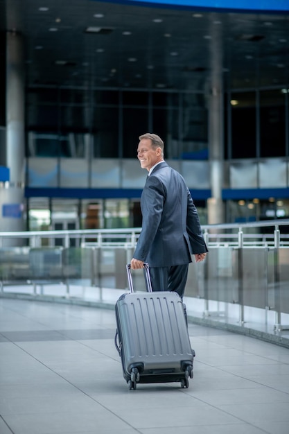 Back view of walking man with suitcase