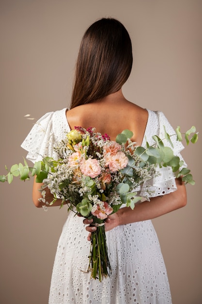 Back view woman holding flowers bouquet