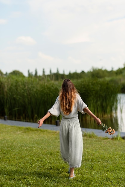 Back view woman holding flowers