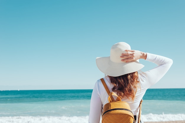 back view of a woman looking at the sea travel concept