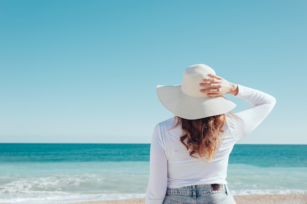 back view of a woman looking at the sea travel concept