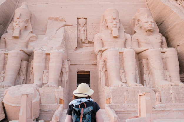 Back view of woman standing in front of Abu Simbel temple in Aswan Egypt