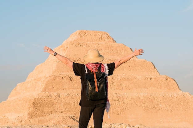 back view of woman standing in front of the step pyramid at Saqqara , Egypt