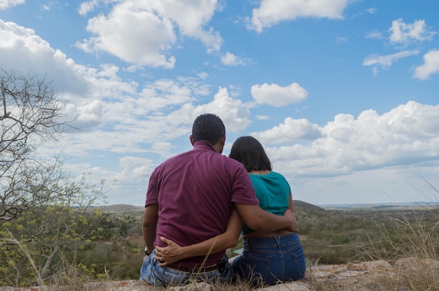 Back view of young couple looking at the horizon from the heights of the hill