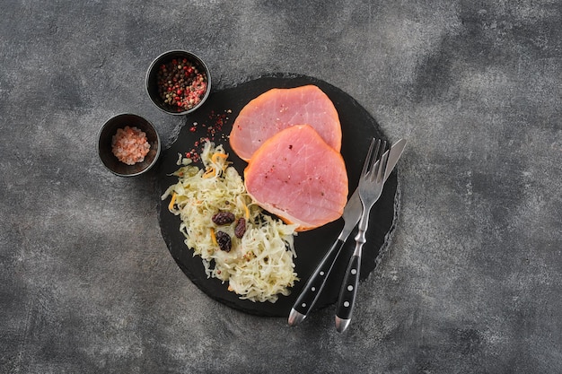 Backed Kasseler pork steak with sauerkraut Smoked pork lion Sliced smoked pork chop on wooden board