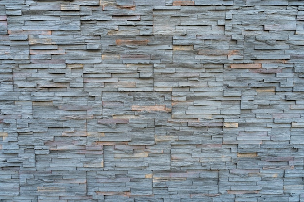 Background arrangement of stones or slabs of different shapes and colors on a wall