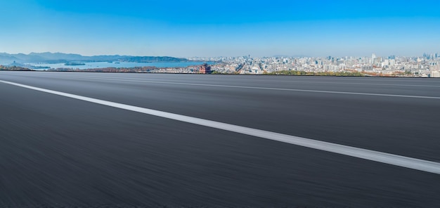 Background of asphalt pavement and urban architectural landscape skyline