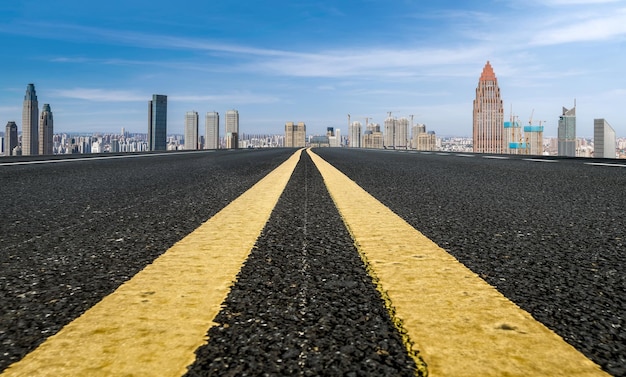 Background of asphalt pavement and urban architectural landscape skyline