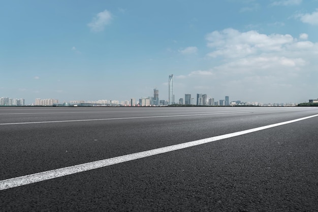 Background of asphalt pavement and urban architectural landscape skyline