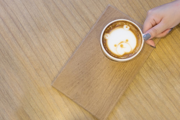 Background of beautiful woman hold cup of coffee on the wood table