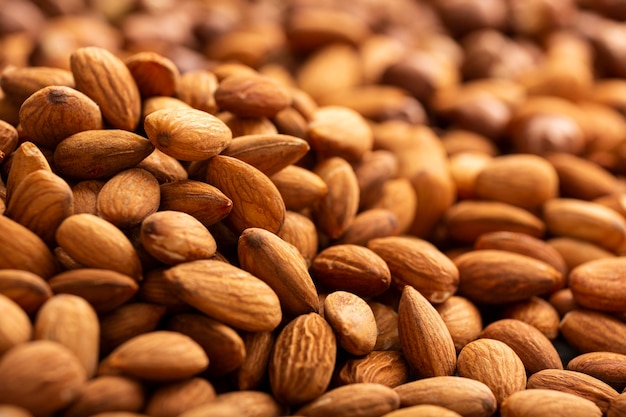 Background of big raw peeled almonds situated arbitrarily