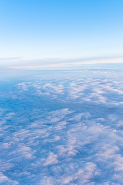 Background of a blue heavenly sky with fluffy dense clouds top view from an airplane vertical frame Sky Gradient