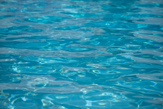 Background of blue water in swimming pool with sun reflection ripple water wave in pool clear water