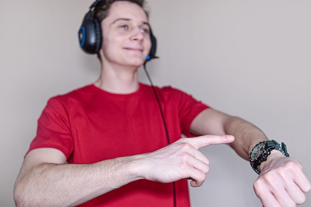 Background blur out of focus bokeh A young guy points his finger at the dial The Concept Of Headphones For Listening To Music By A Person