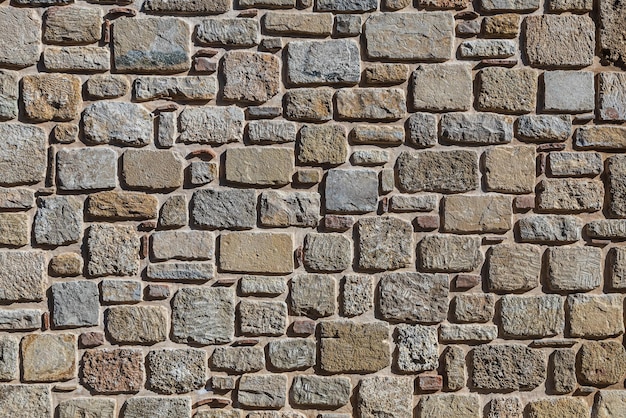 Background of browngray stone wall with leaves and moss Pattern of slate wall texture and background