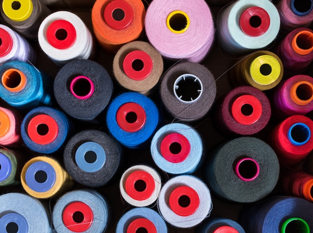 background of cashmere yarn on reels or spools in a knitwear factory in a manufacturing and fashion concept