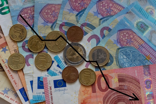 Background of euro banknotes in close-up with a graph of the fall