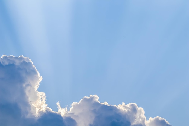 Background from blue sky with sun rays across clouds