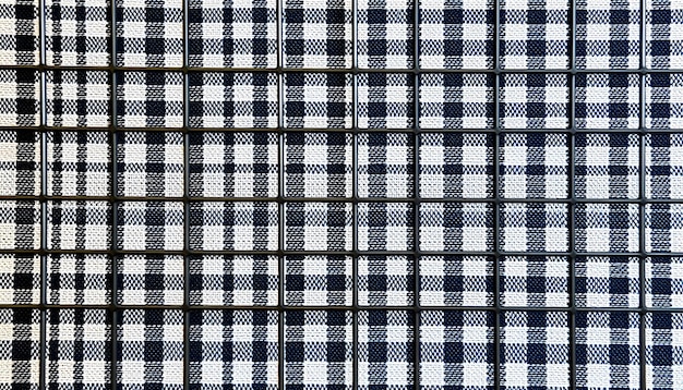 Background from fabric in a cage A piece of checkered fabric closeup Material with straight