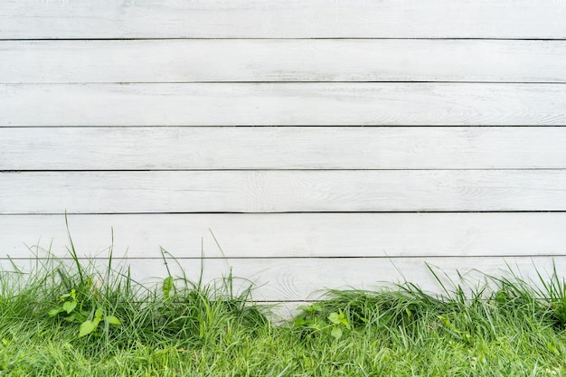 Background from a white fence grass grows below