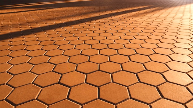 Photo background of geometric hexagon brown cobblestone pavement with light and shadow on surface