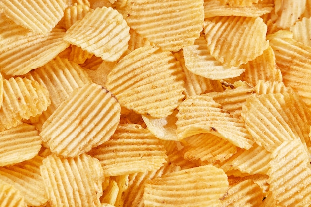 Background of golden wavy corrugated chips  slices