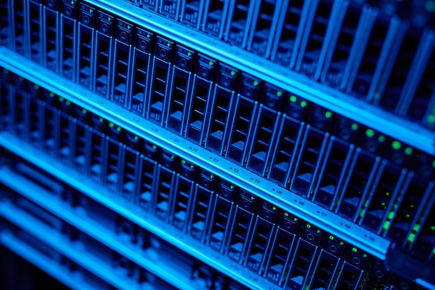 Background image of blade servers in blue neon light stacked in data center copy space