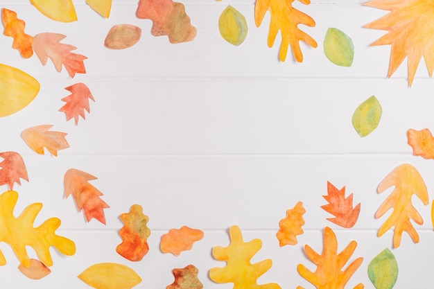 Background image of cut paper red orange and yellow autumn leaves painted in watercolor Copy space top view