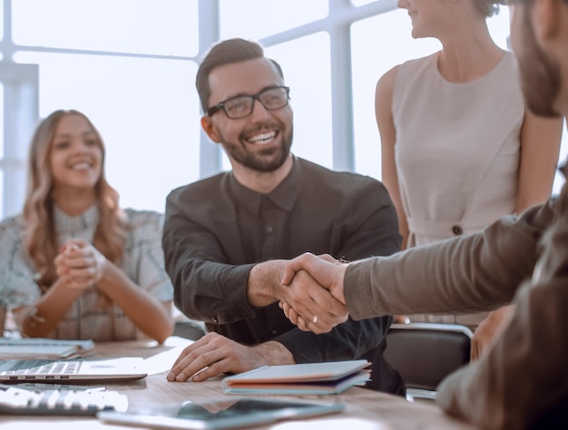 Background image of the handshake of business partners in the office