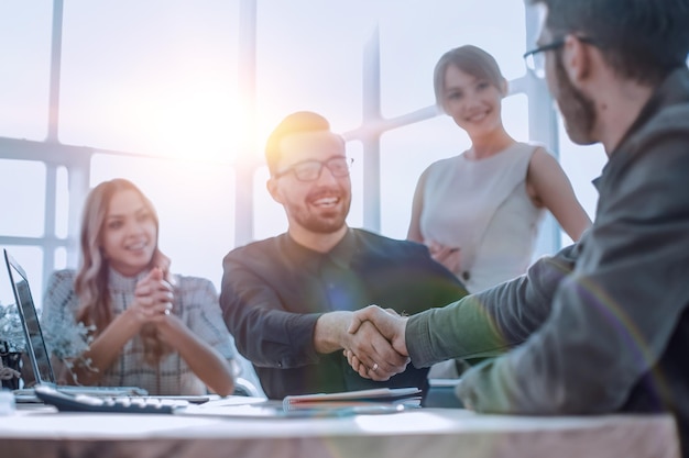 Background image of the handshake of business partners in the office