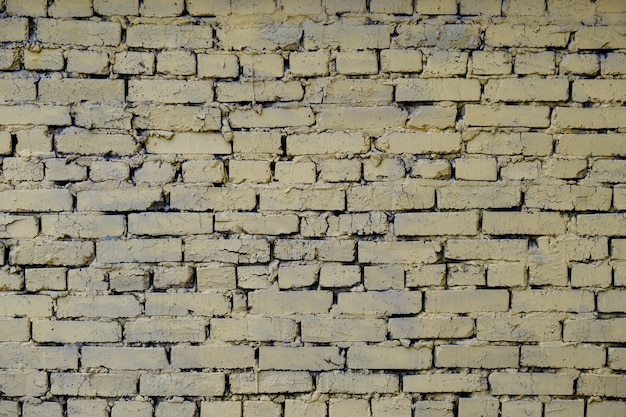 Background in industrial style of painted yellow cracked brick.