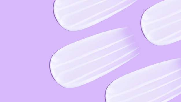 The background is cosmetic Many smears of cream on a pink purple background