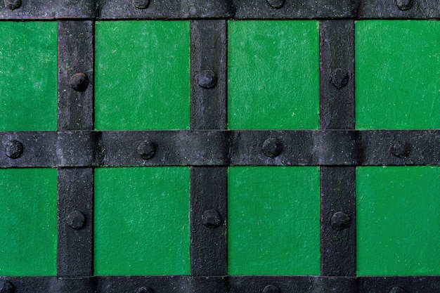 The background is painted with green paint with metal beams and rivets.