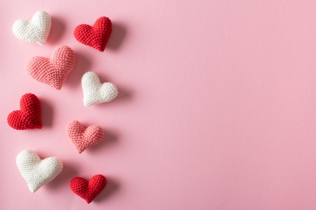 Background of knitted hearts on a light pink background for Valentine's Day